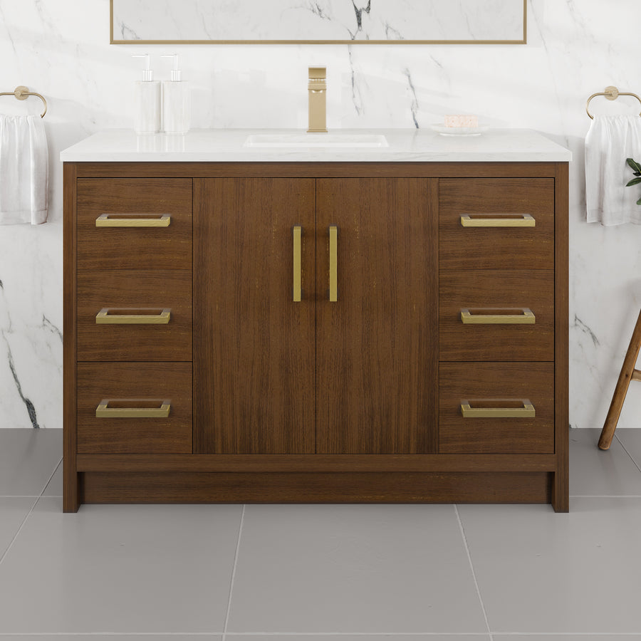 A contemporary Curio 48″ Vanity in a rich walnut wood finish, featuring sleek gold hardware and a pristine Carrara quartz top with an integrated sink. This striking vanity stands out beautifully against the marble wall and gray tile floor, with towel rings mounted on either side.
