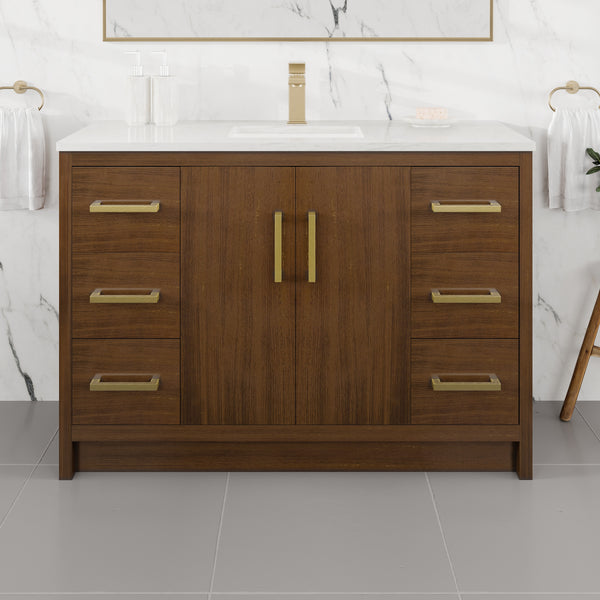 A contemporary Curio 48″ Vanity in a rich walnut wood finish, featuring sleek gold hardware and a pristine Carrara quartz top with an integrated sink. This striking vanity stands out beautifully against the marble wall and gray tile floor, with towel rings mounted on either side.