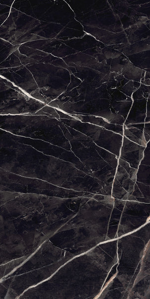 Dark marble surface with a deep black background and irregular white and light gray veins running across, creating a natural, textured pattern.