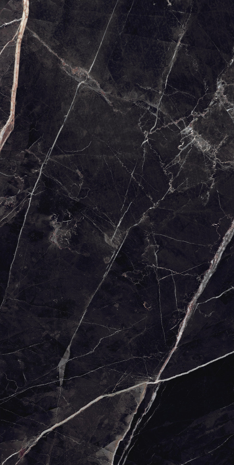 Close-up of a dark, polished marble surface with thin, irregular white and light brown veins running diagonally across the stone, giving it a dramatic and elegant appearance.