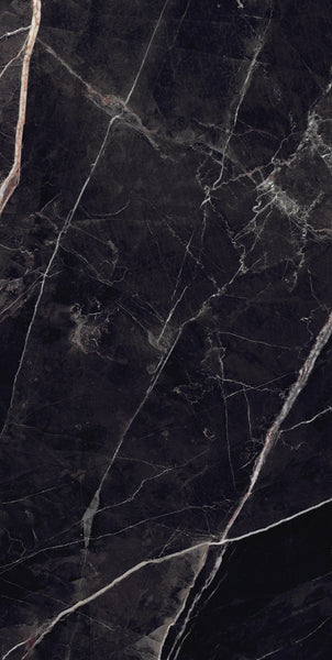 Close-up of a dark, polished marble surface with thin, irregular white and light brown veins running diagonally across the stone, giving it a dramatic and elegant appearance.
