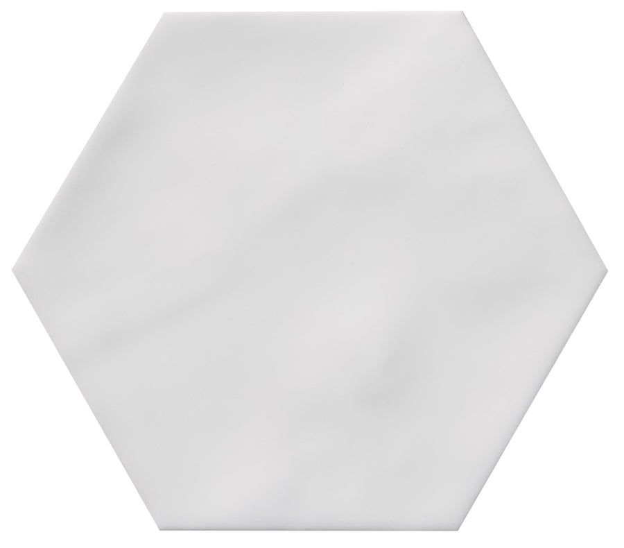 The Zephyr 4.2x4.9 Hexagon Ceramic Tile is a white, flat ceramic tile with smooth edges and a hexagonal shape, shown on a plain white background. Perfect for Mediterranean-inspired accents and available as a special-order item.