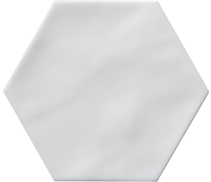 The Zephyr 4.2x4.9 Hexagon Ceramic Tile is a plain white ceramic tile with a smooth surface and hexagon shape, displayed on a white background—special-order for a unique Mediterranean touch.