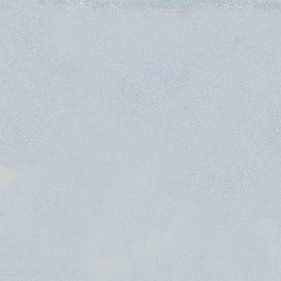 The Avanti 12x12 Glazed Porcelain Tile features a textured, light gray surface with subtle variations and speckles. Its uniform, neutral design offers a calming aesthetic, perfect for spaces seeking a tranquil atmosphere.