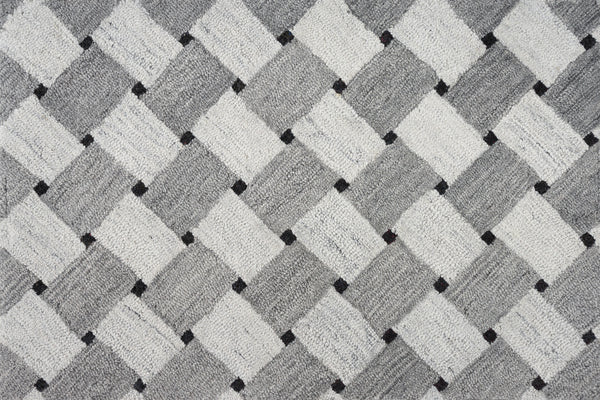 A close-up of the Atrium On Trend Carpet in gray reveals a textured surface with a repeating diamond pattern and small black dots—an elegant, modern flooring choice for contemporary interiors.