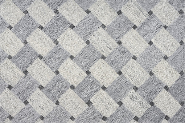 A close-up of the Atrium On Trend Carpet in Ice shows a textured surface with alternating light and dark diamonds in gray, white, and black, forming a modern geometric pattern ideal for contemporary interiors.