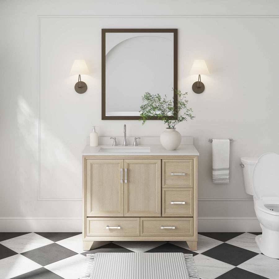 A modern bathroom with the Ashlow 42" Vanity with engineered stone top, rectangular mirror, two wall sconces, potted plant, white sink, toilet, towel rack, and classic black-and-white checkered floor tiles.