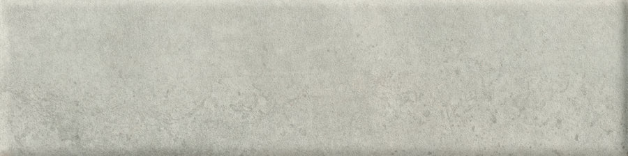The Abode 2.5x9.5 Porcelain Tile offers a rectangular, light gray textured surface with subtle color variations and a slightly rough, mottled finish—perfect for accent features or achieving understated sophistication.