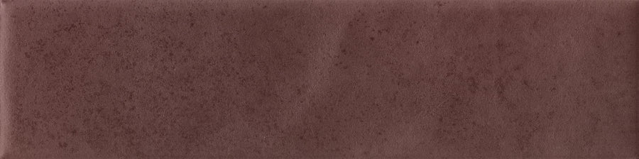 The Abode 2.5x9.5 Porcelain Tile features a smooth, solid maroon surface with subtle speckled and slightly mottled texture, bringing understated accent and modern style to any space.