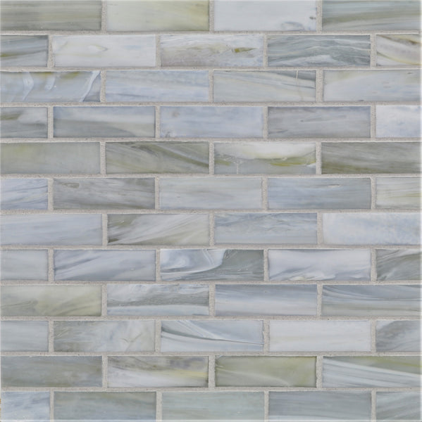 The Agate 1x3 Lucca Mosaic Glass Tile features glossy rectangular pieces in gray, blue, and white with a marbled texture and subtle color variation, arranged in a staggered brick pattern with light gray grout for a modern look.