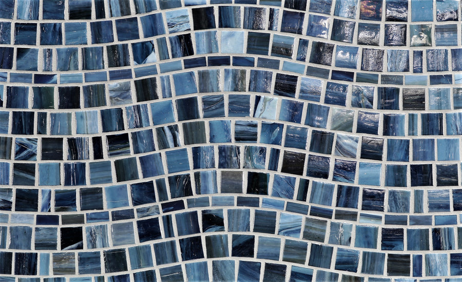 Close-up of a mosaic with small, square blue tiles in wavy lines, creating a dynamic pattern inspired by the intricate textures of Agate Rio Portofino Pearl Mosaic Glass Tile.