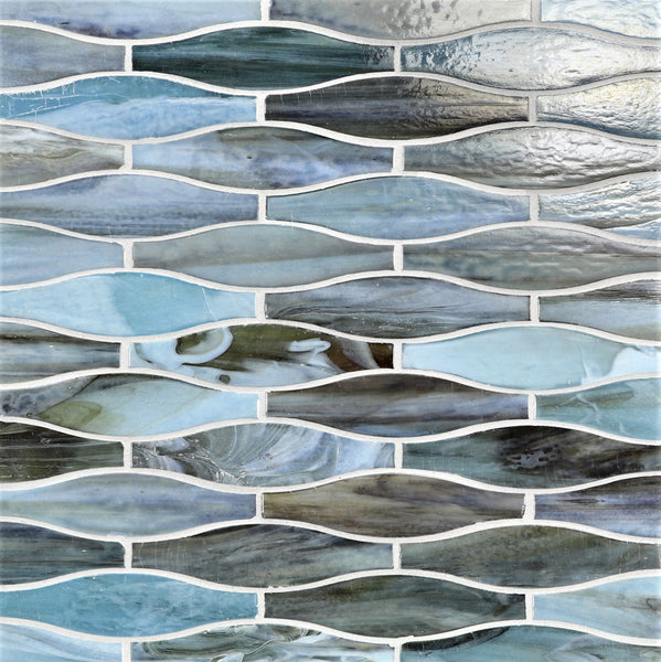 The Agate Taiko Mosaic Glass Tile features blue, gray, and white elongated ovals in a wavy interlocking pattern with white grout for a fluid, water-like look reminiscent of elegant three-dimensional glass mosaics.