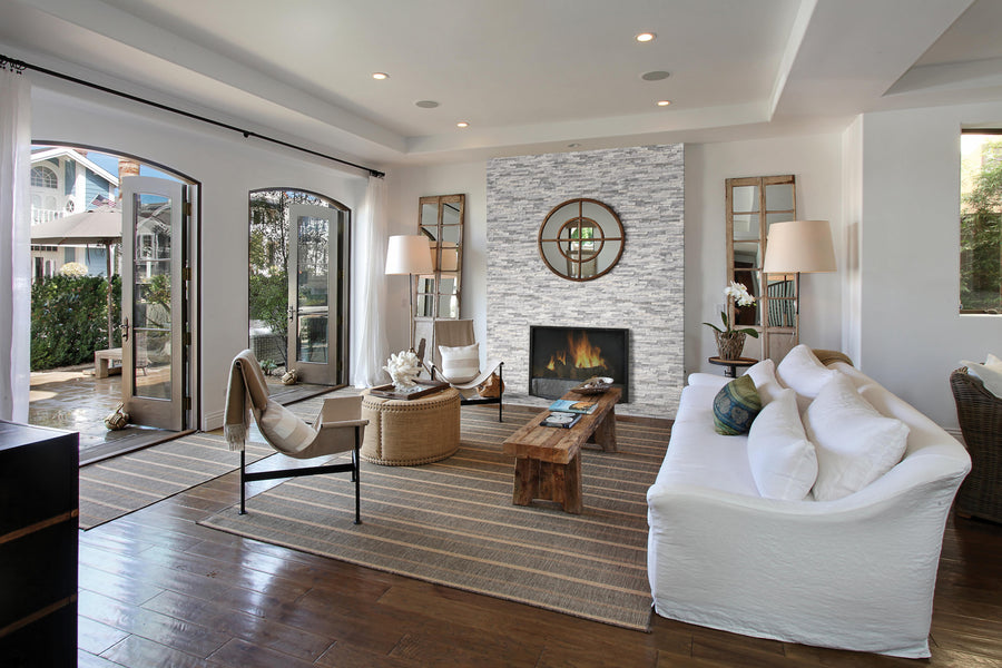 A living room with a fireplace and white couches.