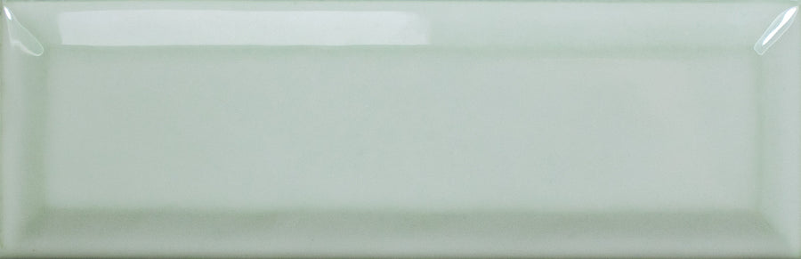 The Alchemist Bevel 2" x 6" Subway Tile in Sage is a rectangular, glossy ceramic tile with slightly beveled edges and a smooth surface that reflects light for a shiny, elegant look.