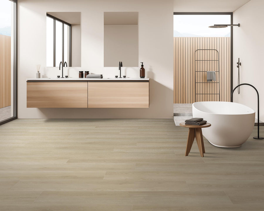 Modern bathroom with light wood flooring, a floating vanity with double sinks, a freestanding white bathtub, a small wooden stool, and large windows letting in natural light. Theres also an outdoor shower visible.