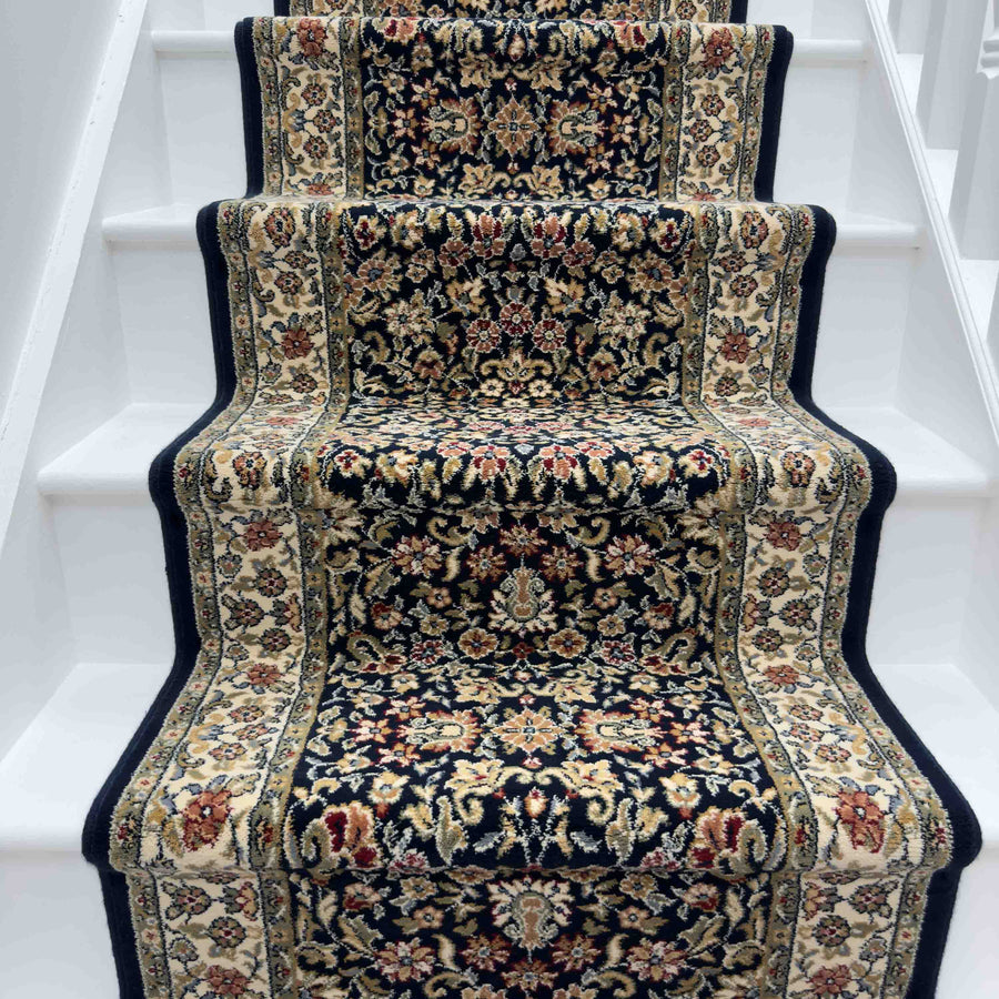The Ancient Garden 57078-1414 Runner Rug, featuring beige, red, and navy floral patterns, adds decorative contrast to white stairs.