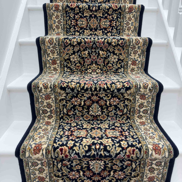 The Ancient Garden 57078-1414 Runner Rug, featuring beige, red, and navy floral patterns, adds decorative contrast to white stairs.
