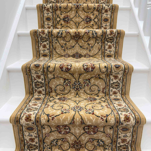 The Ancient Garden 57120-1464 Runner Rug, featuring beige and gold tones with floral and vine designs, covers white stairs for a traditional, elegant look—perfect as an entryway or hallway rug.