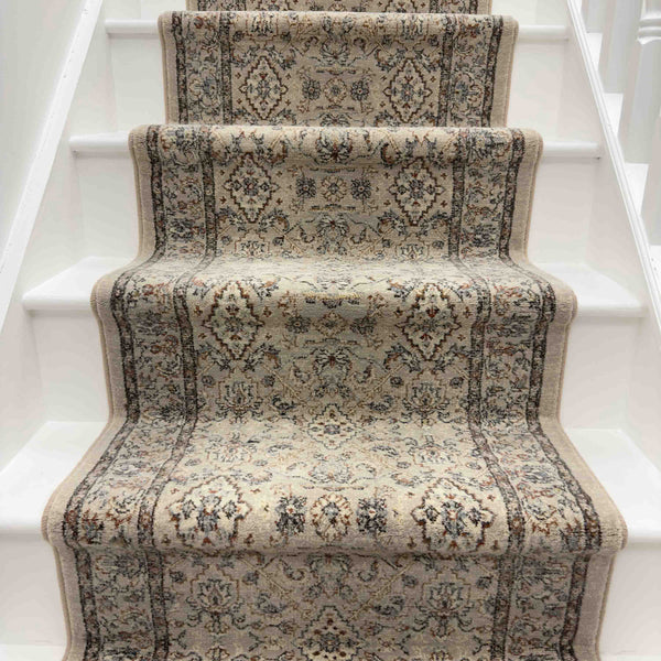 The Ancient Garden 57276-9295 Runner Rug, with its traditional floral design in beige and brown tones, covers the middle of a white-painted staircase and adds intricate elegance to your entryway.