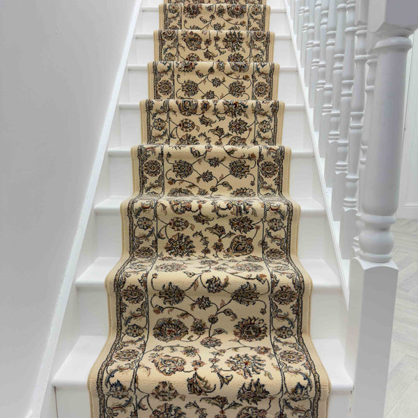 The Ancient Garden 57365-6464 Runner Rug in beige and brown with floral patterns is neatly centered on a white staircase, bordered by white banisters.