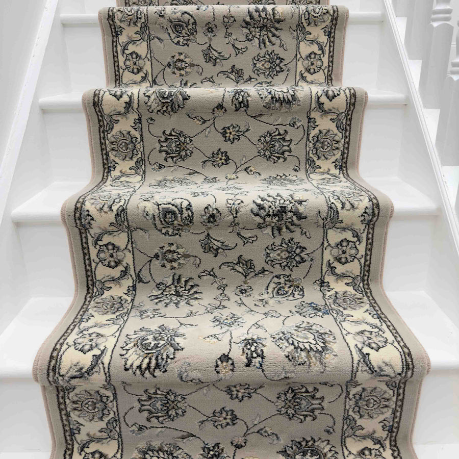 The Ancient Garden 57365-1464 Runner Rug in beige and gray floral pattern enhances the white staircase, adding texture and elegance to the space.