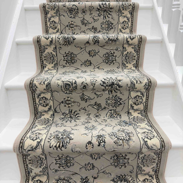 The Ancient Garden 57365-1464 Runner Rug in beige and gray floral pattern enhances the white staircase, adding texture and elegance to the space.