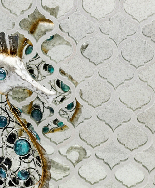 A decorative metallic seahorse with turquoise accents is positioned against a patterned, reflective background, creating mirrored reflections and a textured, artistic effect.