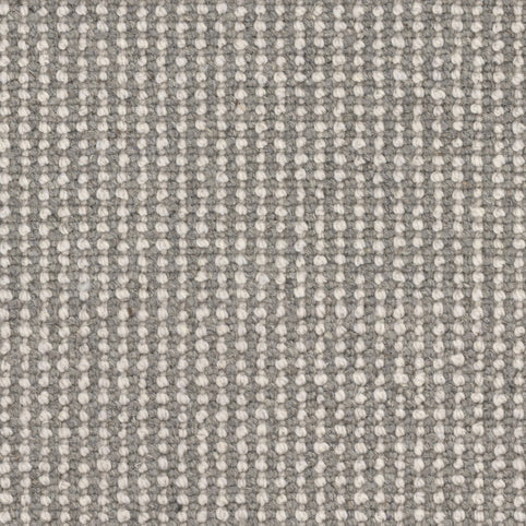 Close-up of Andros Berber Carpet in Antiquity color, featuring a grid-like pattern of small, raised off-white dots on a gray background for a uniform, tightly woven, and durable surface.