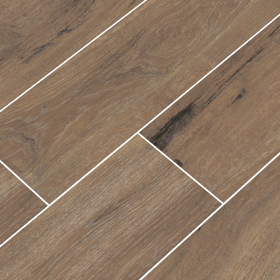Close-up of light brown ceramic tiles with a wood grain pattern, arranged in an offset pattern with visible white grout lines separating each tile.
