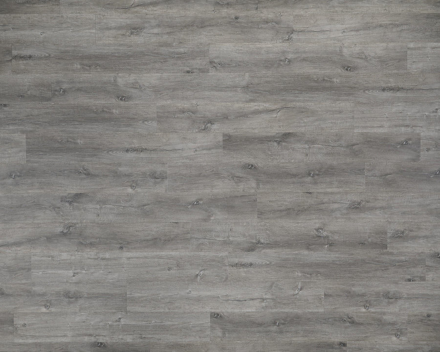 Adura Max 7.1" Vinyl Plank in Aspen Drift features gray, weathered-look floorboards with visible wood grain, smooth and evenly spaced planks, plus natural knots and imperfections for added detail.