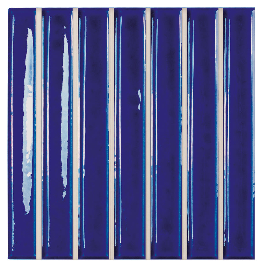 The Astria 4.6" x 4.6" Deco Ceramic Tile in Indigo Glossy features vertical blue stripes with varied shades and textures, separated by fine white lines—ideal for backsplashes or accent walls that need an artistic touch.