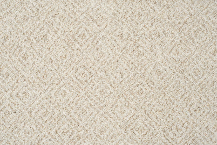 Close-up of Brentwood Berber Carpet in Oatmeal, featuring a soft, woven surface with a repeating diamond pattern—an elegant, beige design that adds subtle geometric interest and pairs well with resilient flooring.
