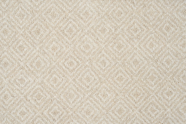 Close-up of Brentwood Berber Carpet in Oatmeal, featuring a soft, woven surface with a repeating diamond pattern—an elegant, beige design that adds subtle geometric interest and pairs well with resilient flooring.