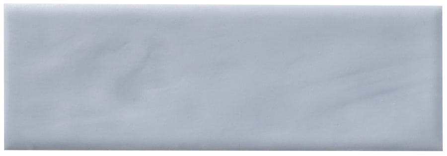 A rectangular, light gray Zephyr 2x6 Ceramic Tile with a smooth, handcrafted look is shown against a white background, evoking refined Mediterranean simplicity.