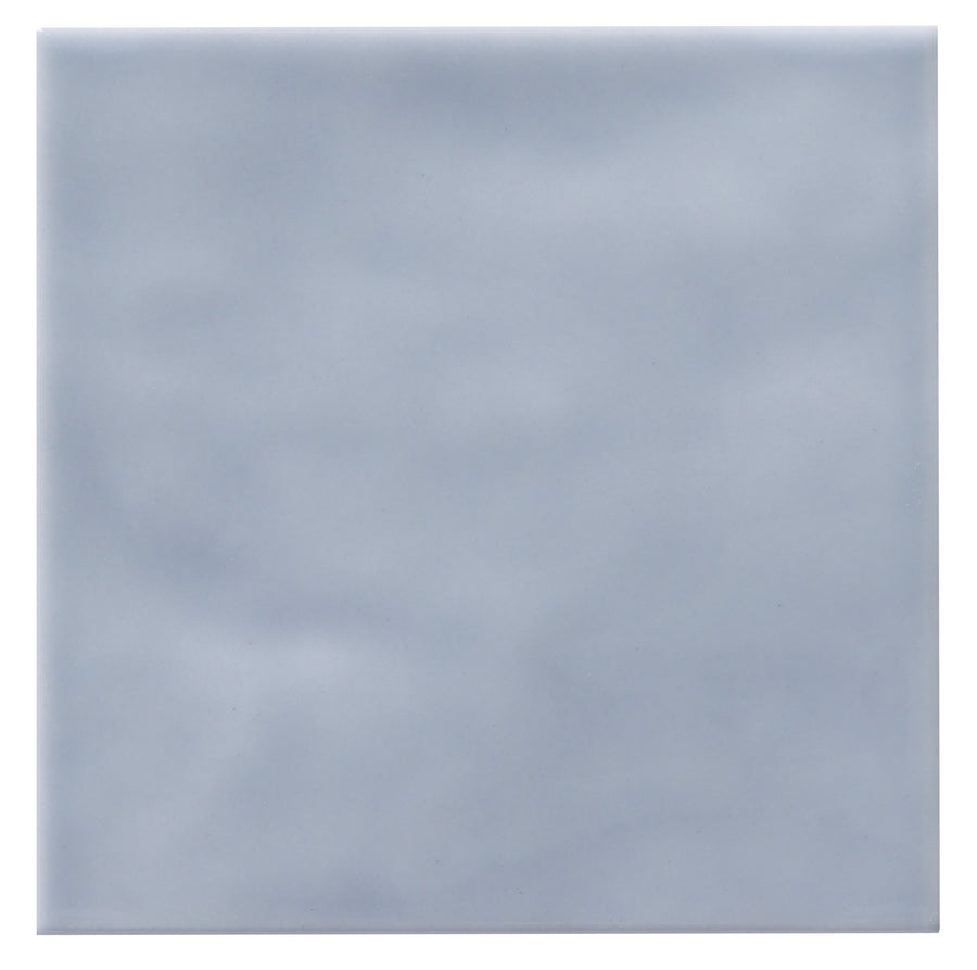 The Zephyr 4x4 Ceramic Tile features a smooth, square surface with a soft, cloudy light gray color and subtle mottled texture. Inspired by Mediterranean design, this tile is available as a special-order item.