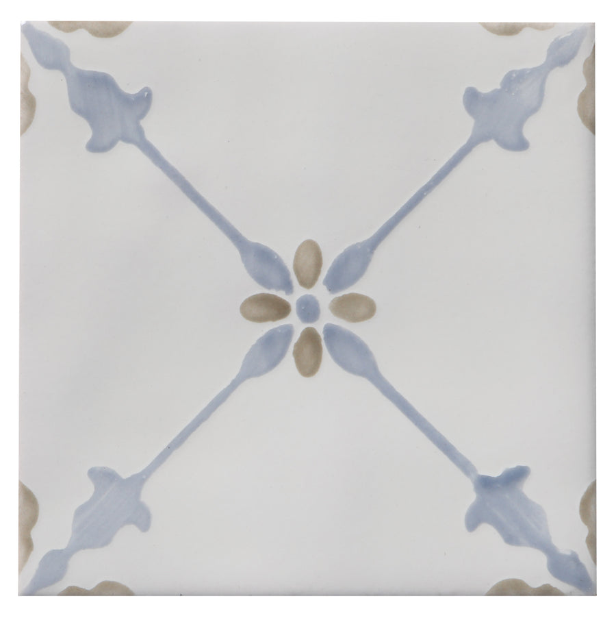 The Zephyr 4x4 Merida Deco Ceramic Tile features a square design with a Mediterranean-inspired pattern of light blue lines and tan ovals radiating from the center on a white ceramic background.