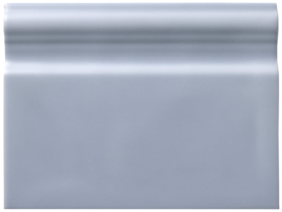 The Zephyr 6x8 Ceramic Baseboard is a rectangular, glossy light gray tile with a raised rounded top edge, inspired by handcrafted luxury and Mediterranean baseboard designs from our special-order collections.