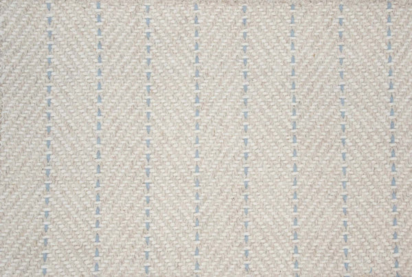 Close-up of Angola Berber Carpet in Beach color, featuring a cream base with blue vertical dashed lines in a herringbone pattern, evoking Angola flooring. The soft, slightly raised texture adds contemporary appeal.