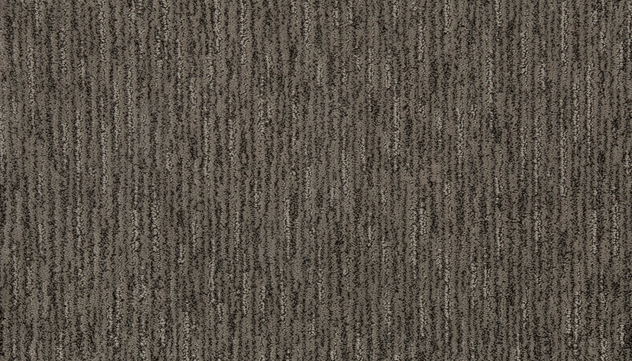A close-up of Beautiful Elements Pet Friendly Carpet in Illusion shows a brown and gray textured surface with subtle vertical stripes, offering stylish and durable flooring that’s ideal for pet owners.