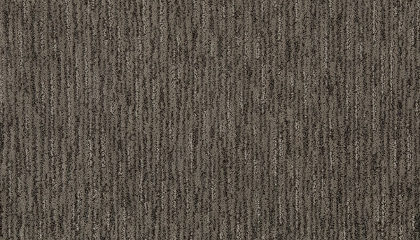 A close-up of Beautiful Elements Pet Friendly Carpet in Illusion shows a brown and gray textured surface with subtle vertical stripes, offering stylish and durable flooring that’s ideal for pet owners.