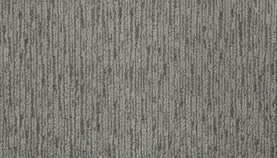 Close-up of Beautiful Elements Pet Friendly Carpet in Bliss, showcasing a textured, vertical striped pattern with shades of gray and black. This luxury carpet is soft, pet-friendly, and features a subtle modern design.