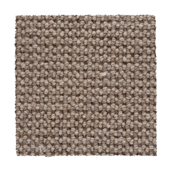 A close-up of a Bellarine Berber Carpet swatch in Cork shows its tightly looped, textured weave in beige and light brown tones, highlighting the carpet's durability and design against a white background.