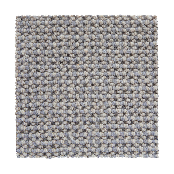 A square swatch of Bellarine Berber Carpet in Sand Beach shows a tightly woven, chunky pattern. With straight edges and a soft yet durable surface, it’s ideal for those looking for a luxury carpet option.