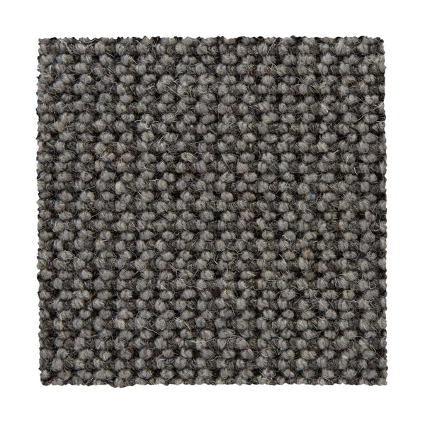 A square swatch of Bellarine Berber Carpet in Mindful Gray, featuring a loop-pile texture and tightly woven surface, is shown on a white background—highlighting this carpet's refined style and durability.