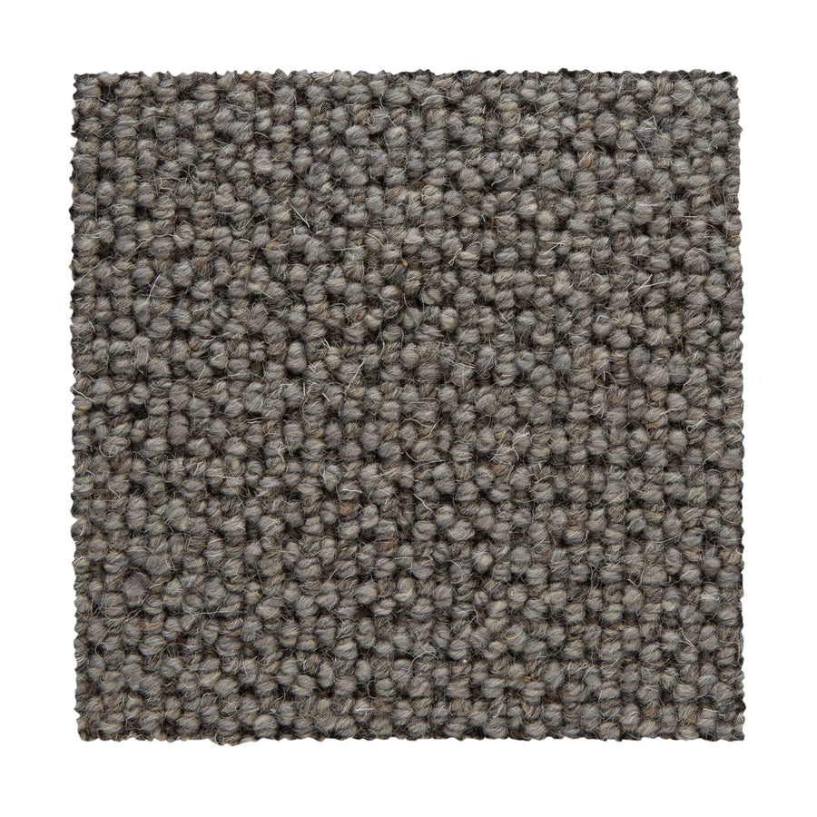 A square swatch of Bellarine Berber Carpet in Gray Matter showcases textured loop-pile fibers in light and dark gray tones on a white base, emphasizing its stylish look and durability as a carpet option.