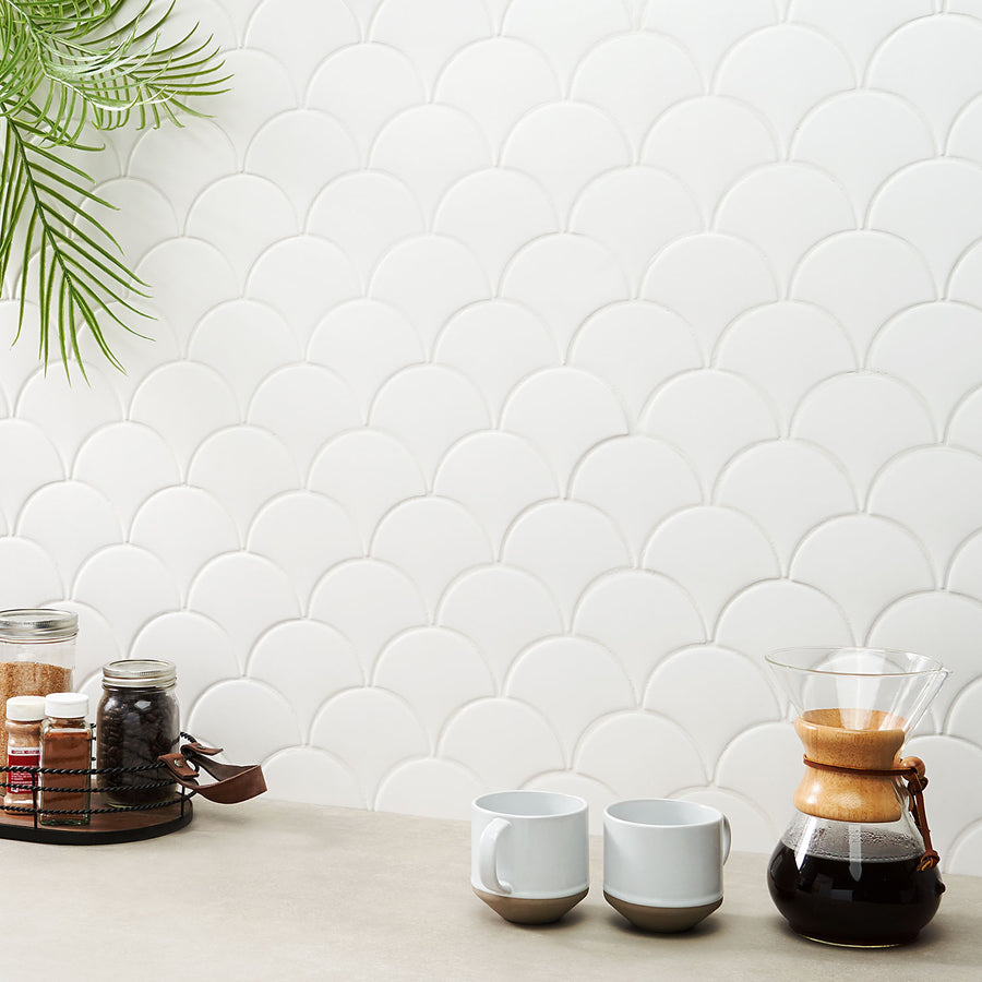 A coffee maker and cups on a counter.