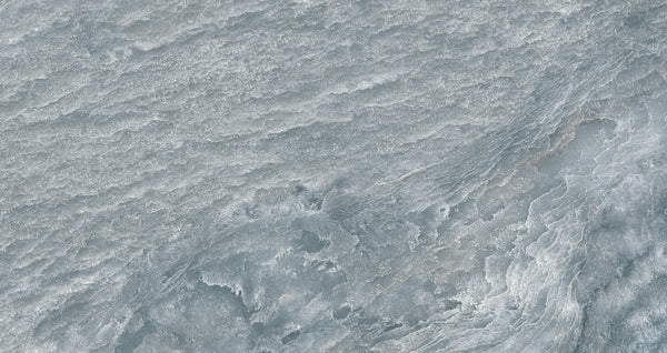 A close-up of an icy, textured surface in gray and white evokes the elegance of Brazilian Slate, mirroring the intricate look and wintry feel of Amazonia 24x48 Glazed Porcelain Tile.
