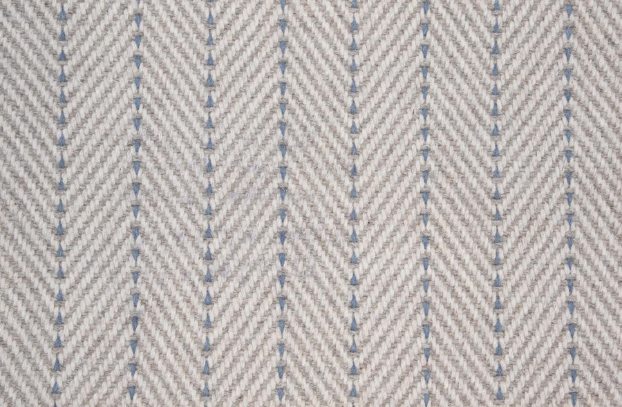 Close-up of Angola Berber Carpet in Bluestone, featuring a textured herringbone pattern that mimics durable flooring and offers contemporary style with repeating V-shaped, symmetrical woven lines.