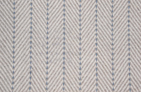 Close-up of Angola Berber Carpet in Bluestone, featuring a textured herringbone pattern that mimics durable flooring and offers contemporary style with repeating V-shaped, symmetrical woven lines.