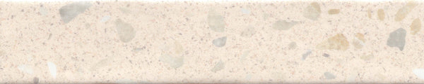 A close-up of Fragmento 2x10 Ceramic Tile in Bone Voyage shows a smooth beige surface with light brown, gray, and cream specks and patches. The subtle terrazzo-inspired pattern adds gentle visual interest to the ceramic tile.